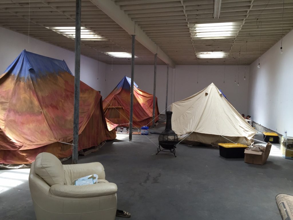 Bell tents being painted by scenic artists